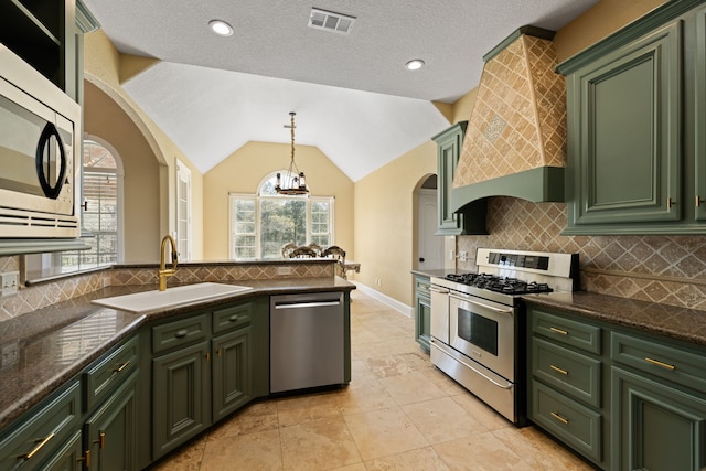8536 Prince William Ct, Montgomery, TX 77316 - kitchen featuring green cabinetry, appliances with stainless steel finishes, arched walkways, a sink, and custom exhaust hood