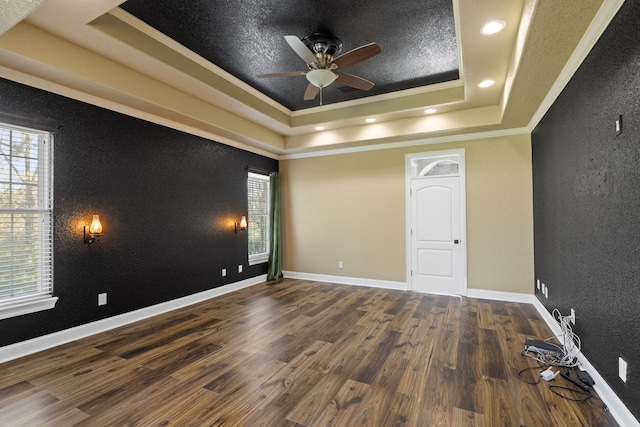 8536 Prince William Ct, Montgomery, TX 77316 - empty room featuring a raised ceiling, healthy amount of natural light, ornamental molding, a ceiling fan, and wood finished floors