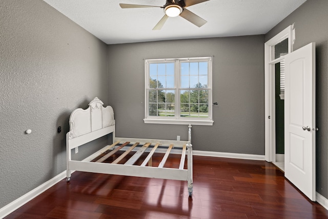 8536 Prince William Ct, Montgomery, TX 77316 - unfurnished bedroom with wood finished floors, baseboards, a textured wall, and a ceiling fan