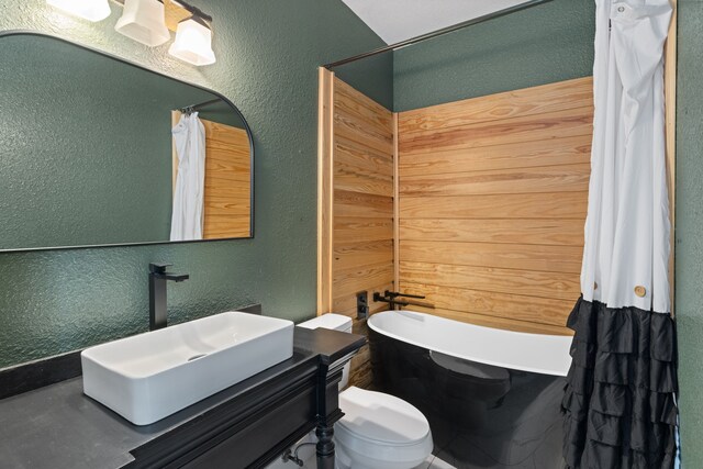 8536 Prince William Ct, Montgomery, TX 77316 - bathroom with a textured wall, a freestanding bath, toilet, and vanity