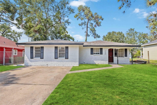 single story home featuring brick siding, concrete driveway, a front lawn, and fence