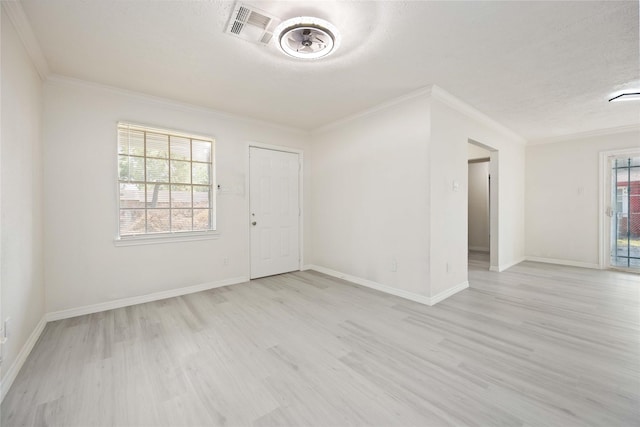 unfurnished room with crown molding, light wood-style floors, visible vents, and baseboards