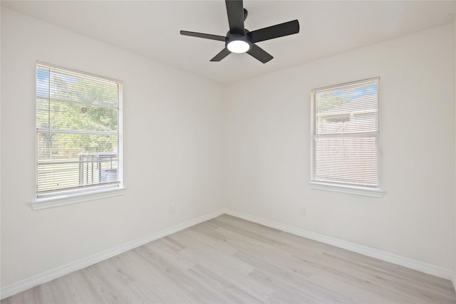 spare room featuring light wood-type flooring, baseboards, and a ceiling fan