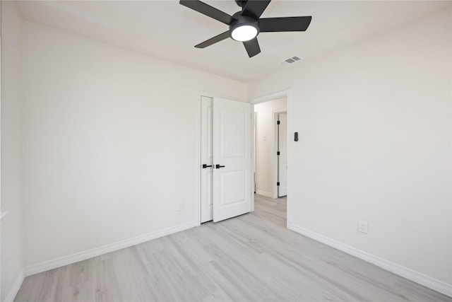 spare room with a ceiling fan, baseboards, visible vents, and light wood finished floors