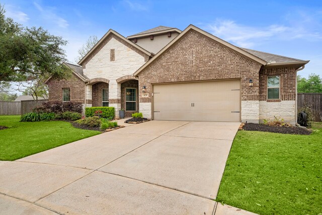 4738 Trickle Creek Ct, Fulshear, TX 77441 - french country home with stone siding, an attached garage, driveway, brick siding, and roof with shingles