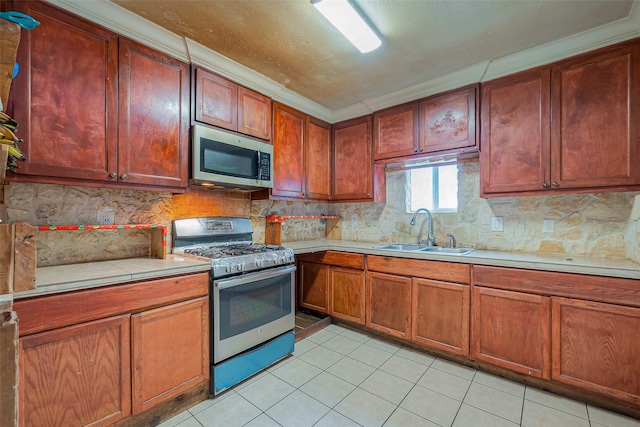 6009 Crane St, Houston, TX 77026 - kitchen featuring brown cabinets, stainless steel appliances, backsplash, a sink, and light tile patterned flooring