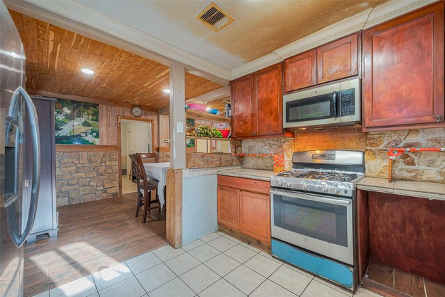 6009 Crane St, Houston, TX 77026 - kitchen featuring light countertops, visible vents, appliances with stainless steel finishes, and decorative backsplash