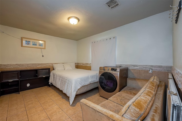 6009 Crane St, Houston, TX 77026 - bedroom featuring visible vents, a wainscoted wall, light tile patterned floors, and washer / clothes dryer