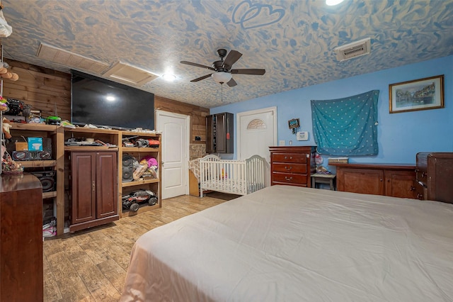 6009 Crane St, Houston, TX 77026 - bedroom with attic access, visible vents, light wood finished floors, and a ceiling fan