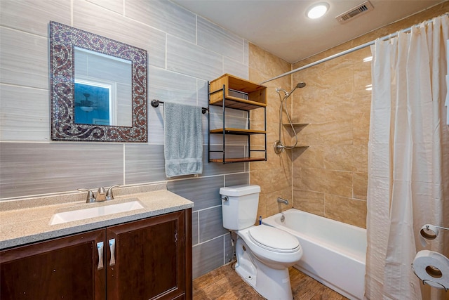6009 Crane St, Houston, TX 77026 - full bath with visible vents, toilet, vanity, tile walls, and shower / bath combo with shower curtain