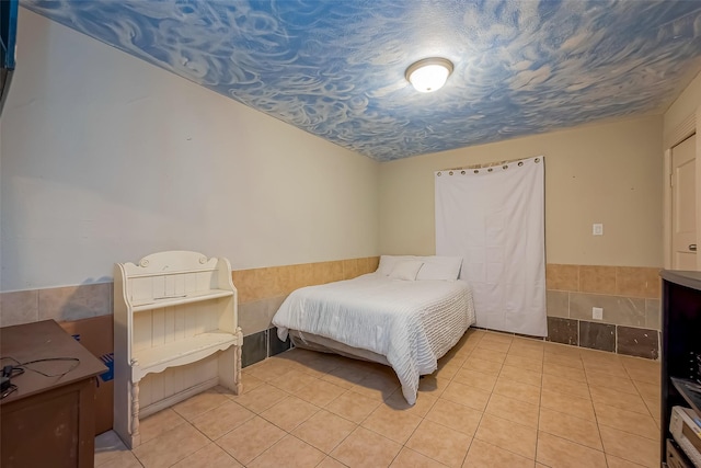 6009 Crane St, Houston, TX 77026 - bedroom featuring a wainscoted wall and light tile patterned floors