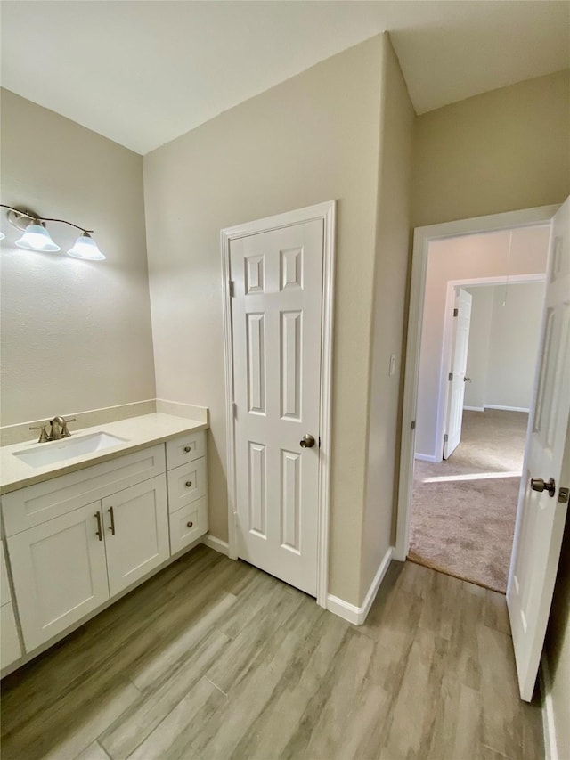 13926 Leabrandon Ln, Houston, TX 77045 - bathroom with vanity, baseboards, and wood finished floors