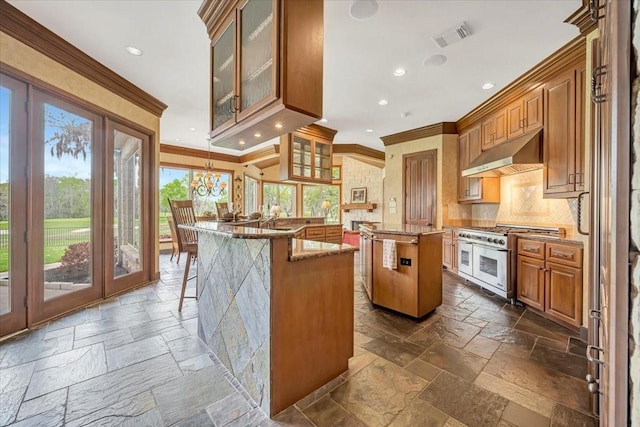 2023 Greenwood Oaks Dr, Houston, TX 77062 - kitchen featuring stone tile floors, double oven range, a kitchen island, under cabinet range hood, and crown molding