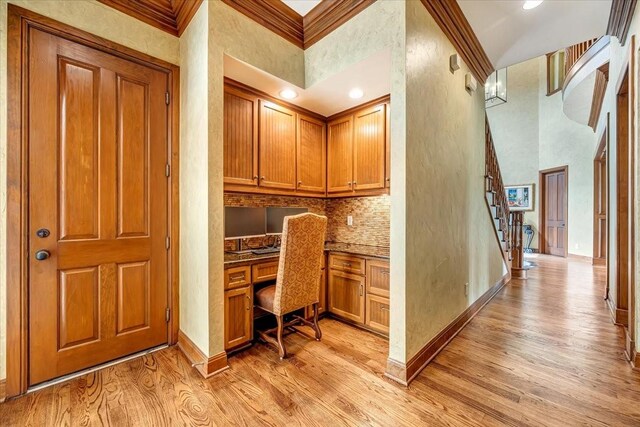2023 Greenwood Oaks Dr, Houston, TX 77062 - office area featuring baseboards, a high ceiling, light wood-style flooring, ornamental molding, and built in desk