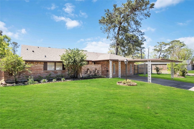 single story home with an attached carport, brick siding, a front lawn, and driveway