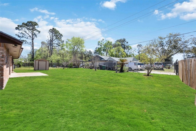 view of yard with an outbuilding, a storage shed, and a fenced backyard