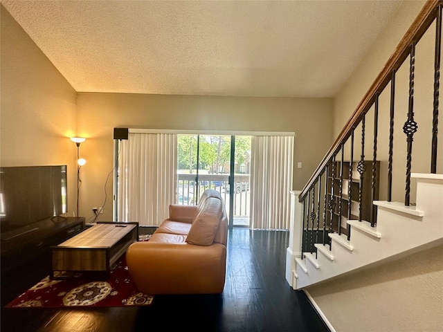 12900 Walden Rd Unit 302C, Montgomery, TX 77356 - living room featuring a textured ceiling, wood-type flooring, and stairs