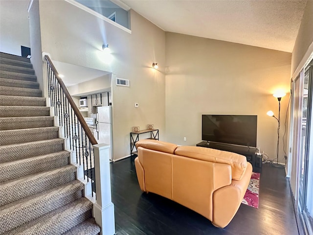 12900 Walden Rd Unit 302C, Montgomery, TX 77356 - living area with dark wood finished floors, stairway, high vaulted ceiling, and healthy amount of natural light