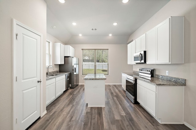5899 Skylane Dr, Montgomery, TX 77316 - kitchen featuring appliances with stainless steel finishes, a sink, a kitchen island, dark wood finished floors, and vaulted ceiling