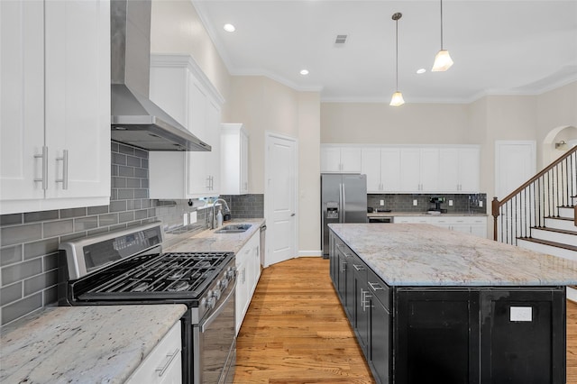 4314 Gibson St Unit A, Houston, TX 77007 - kitchen with appliances with stainless steel finishes, wall chimney exhaust hood, ornamental molding, a center island, and white cabinetry