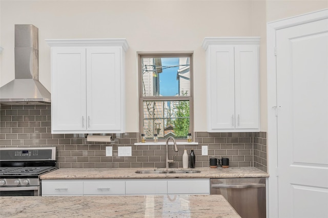 4314 Gibson St Unit A, Houston, TX 77007 - kitchen with wall chimney range hood, stainless steel appliances, white cabinetry, decorative backsplash, and light stone counters
