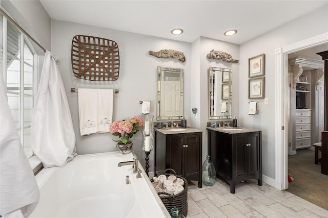 834 Lamonte Ln, Houston, TX 77018 - bathroom featuring two vanities, recessed lighting, a bathing tub, marble finish floor, and a sink