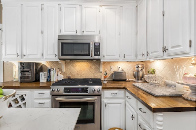 834 Lamonte Ln, Houston, TX 77018 - kitchen featuring stainless steel appliances, wood counters, and white cabinetry
