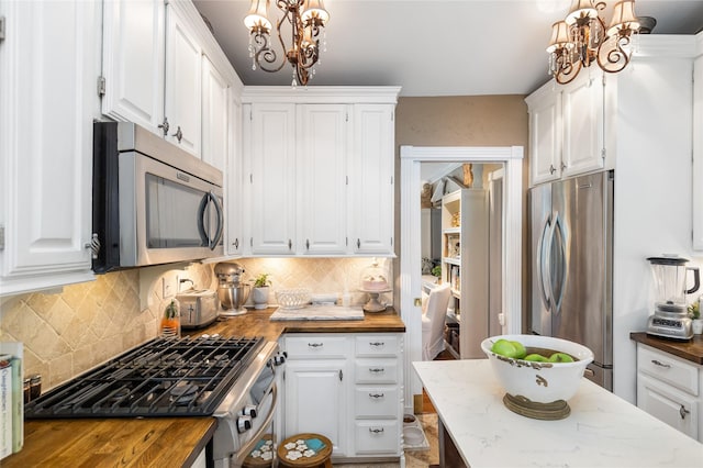 834 Lamonte Ln, Houston, TX 77018 - kitchen featuring a chandelier, white cabinetry, appliances with stainless steel finishes, and butcher block countertops