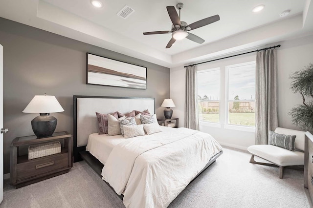 carpeted bedroom featuring recessed lighting, visible vents, and a raised ceiling