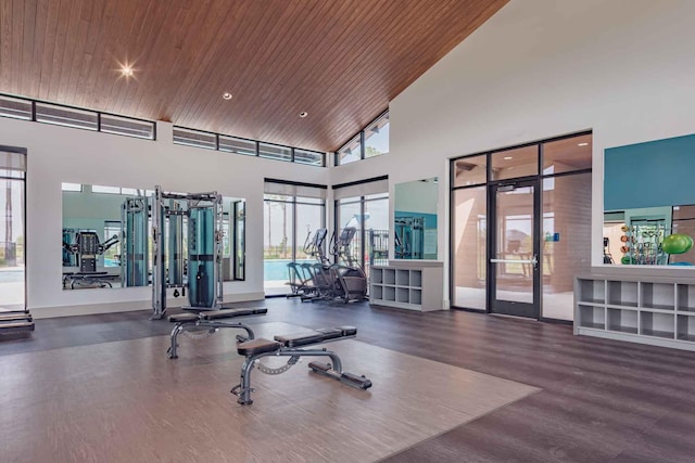 exercise room featuring wood finished floors, wood ceiling, french doors, and a towering ceiling