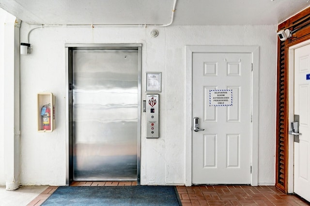 interior space featuring elevator and brick floor