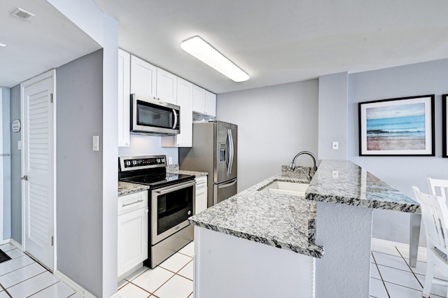 kitchen featuring light stone counters, visible vents, appliances with stainless steel finishes, and a sink