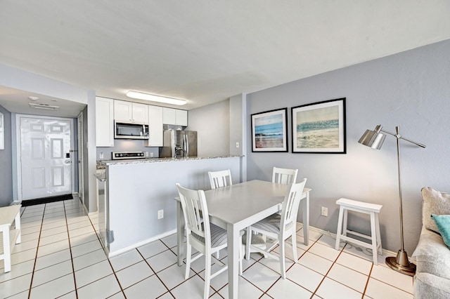 dining area with light tile patterned floors and baseboards