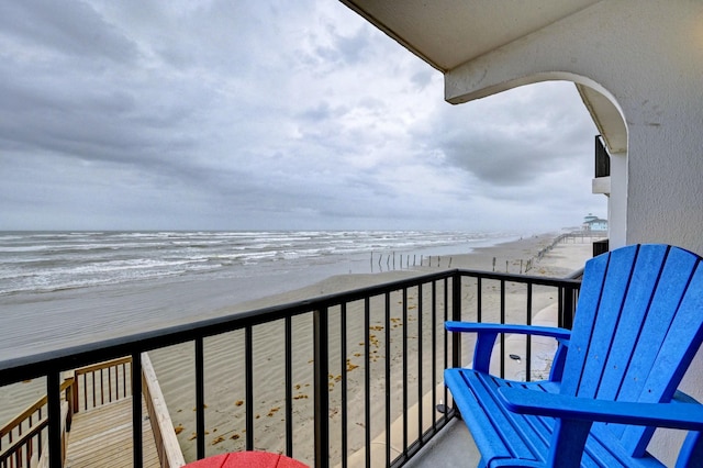 balcony featuring a view of the beach and a water view