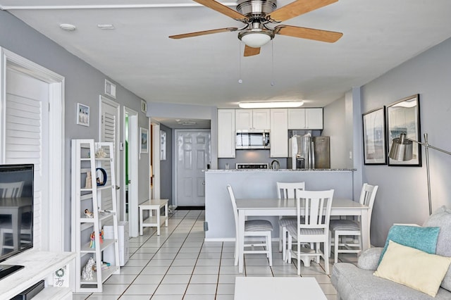 interior space with light tile patterned flooring and a ceiling fan