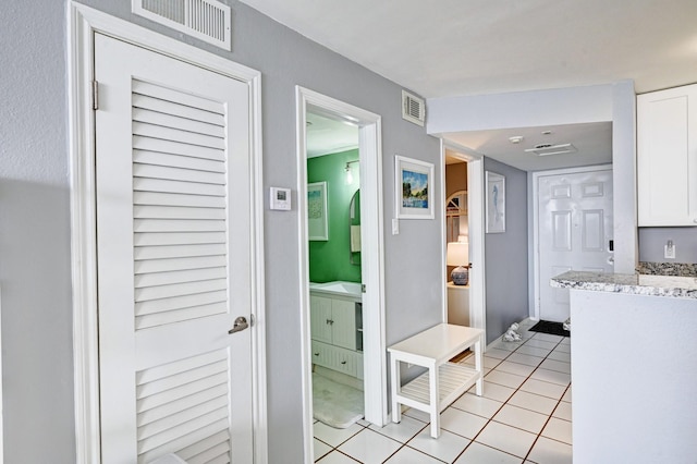 corridor featuring light tile patterned floors and visible vents