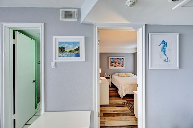 hallway with wood finished floors and visible vents