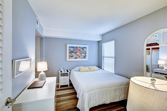 bedroom featuring visible vents and dark wood-type flooring