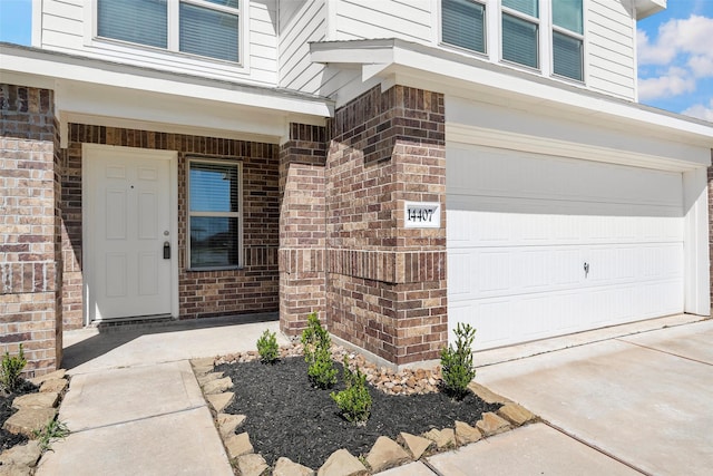 14407 Woodcott Warren Way, Rosharon, TX 77583 - doorway to property with an attached garage, brick siding, and driveway