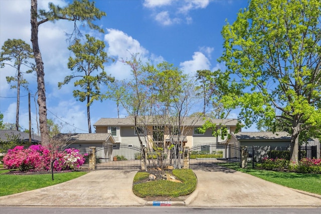 view of front facade featuring a gate, a fenced front yard, and driveway