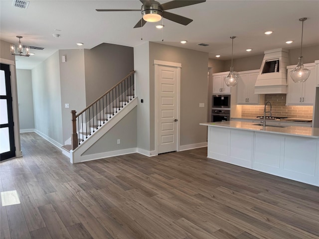 16040 Mason Run Dr, Houston, TX 77079 - kitchen with stainless steel appliances, premium range hood, white cabinetry, tasteful backsplash, and recessed lighting
