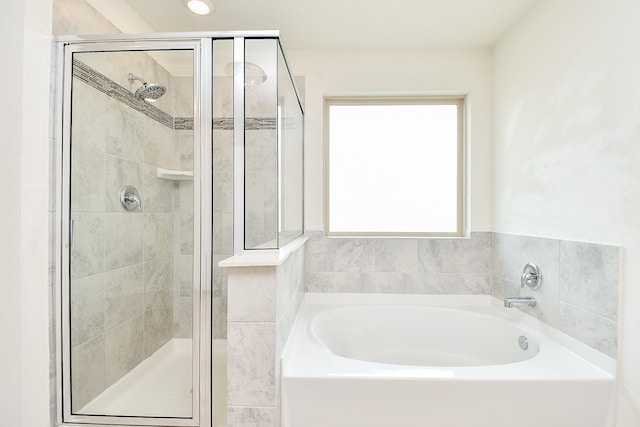 bathroom with a garden tub and a stall shower