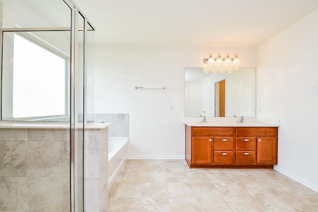 bathroom with a bath, a sink, a chandelier, and double vanity