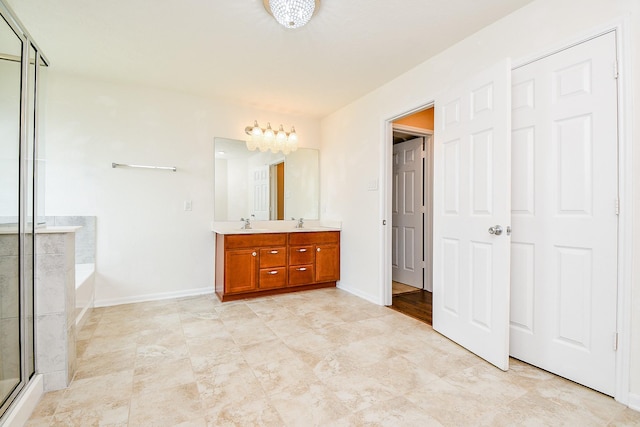 full bath featuring double vanity, a sink, baseboards, a garden tub, and a stall shower