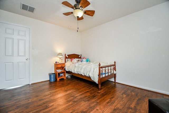 bedroom featuring baseboards, wood finished floors, visible vents, and a ceiling fan