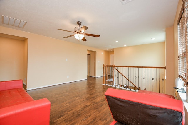 living area with recessed lighting, wood finished floors, visible vents, an upstairs landing, and ceiling fan