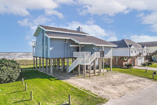 23155 Gulf Dr, Galveston, TX 77554 - rear view of property featuring a residential view, a chimney, a yard, and a shingled roof