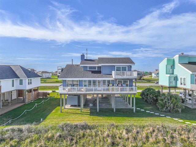 23155 Gulf Dr, Galveston, TX 77554 - back of property with a patio, a balcony, a yard, a shingled roof, and a residential view