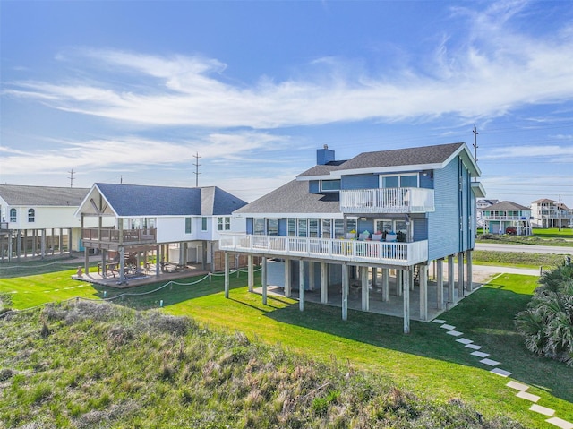 23155 Gulf Dr, Galveston, TX 77554 - rear view of house featuring a balcony, a lawn, roof with shingles, and a chimney