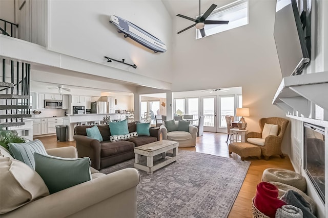 23155 Gulf Dr, Galveston, TX 77554 - living area with light wood-style flooring, a ceiling fan, and a towering ceiling